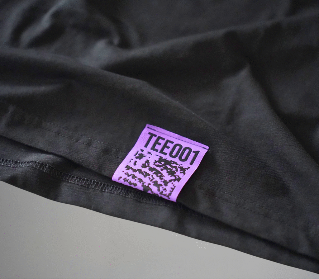 Purple label with TEE001 code and hidden QR detail on the HELIX t-shirt